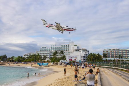 Téléchargez les photos : St. Barth Executive Pilatus PC-12 NGX survolant Maho Beach avant d'atterrir sur l'aéroport international Princess Juliana SXM à Sint Maarten, Pays-Bas Caraïbes. - en image libre de droit