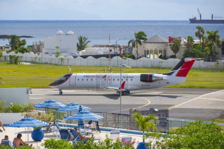 Téléchargez les photos : Décollage d'Air Century Bombardier CRJ200 à l'aéroport international Princess Juliana SXM près de Maho Beach à Sint Maarten, aux Pays-Bas. - en image libre de droit