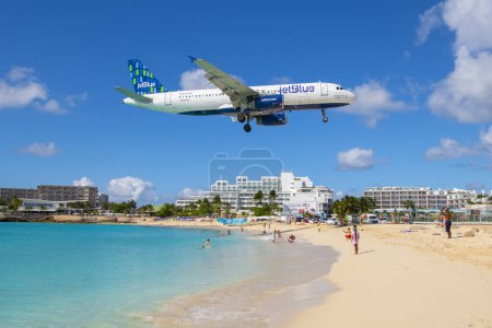Téléchargez les photos : JetBlue Airways Airbus 320 survolant Maho Beach avant d'atterrir sur l'aéroport international Princess Juliana SXM à Sint Maarten, Pays-Bas Caraïbes. - en image libre de droit