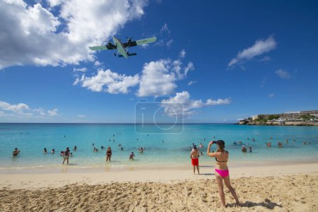 Téléchargez les photos : Maho Beach avec des gens qui regardent l'avion atterrir sur l'aéroport international Princess Juliana SXM à Sint Maarten, Pays-Bas Caraïbes. - en image libre de droit