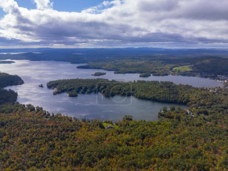 Téléchargez les photos : Vue aérienne du lac Vancpesaukee avec du soleil à travers les nuages en automne de la ville de Moutonborough, New Hampshire NH, États-Unis. - en image libre de droit