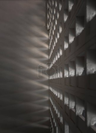 Foto de La luz del sol brilla a través de los canales de luz de la pared del antiguo gimnasio. Las paredes de hormigón tienen agujeros para que la luz del sol penetre a través de los agujeros desde el exterior, concepto de luz y sombra, espacio para el texto, enfoque selectivo. - Imagen libre de derechos