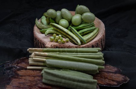 Photo for Composition of green snacks in assortment with different tastes and different shapes with Roasted sugar snap peas, Matcha cream covered biscuit sticks, Matcha latte crepe cookie and Matcha coated almonds laid out on a wooden substrate. Green desserts - Royalty Free Image