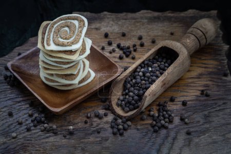 Photo for Traditional black pepper cookies in the wooden plate. Its flavour has a sweet and hot spicy taste from black pepper, Selective Focus. - Royalty Free Image