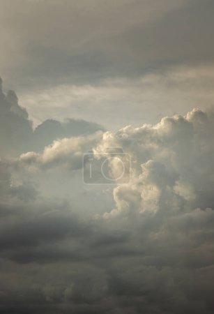 Foto de The sun shines through the clouds in the evening sky with dramatic light. The shape of the clouds evokes imagination and creativity, They can be used as wallpaper. Copy space, Selective focus. - Imagen libre de derechos