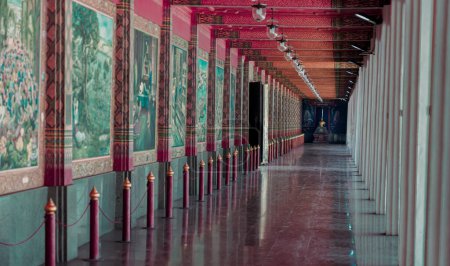 Foto de Suphan buri, Tailandia Apr 22, 2023 - Una perspectiva atenuante Vista interior de la pasarela en Wat Pa Lelai Worawihan (Templo Pa Lelai Worawihan) con la pared de pintura mural del templo budista decorada (literatura clásica Khun Chang Khun Phaen). Arte tailandés an - Imagen libre de derechos