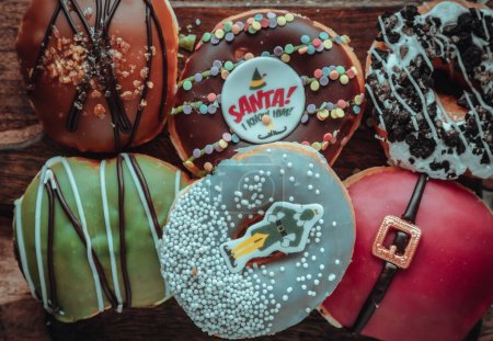 Foto de Muchos Donuts esmaltados colocados en la tabla de cortar de madera. El concepto de deliciosos y deliciosos donuts acristalados increíbles, Vista superior, Espacio para el texto, Enfoque selectivo. - Imagen libre de derechos