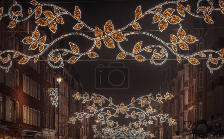 Photo for London, UK - Dec 25, 2023 - Christmas decoration led lights display. Dramatic view of the traditional Christmas decoration lights hanging above Marylebone street during dusk, The Spirit of Christmas, Light Festival in London, Space for text, Selectiv - Royalty Free Image