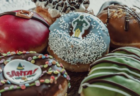 Foto de Muchos Donuts esmaltados colocados en la tabla de cortar de madera. El concepto de deliciosos y deliciosos donuts acristalados increíbles, Espacio para el texto, enfoque selectivo. - Imagen libre de derechos