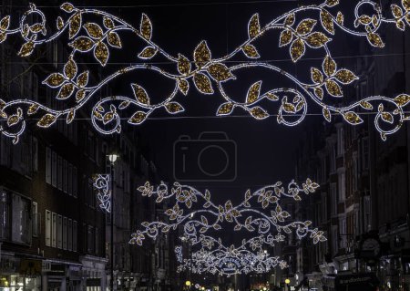 Photo for London, UK - Dec 25,2023 - Christmas decoration led lights display. Dramatic view of the traditional Christmas decoration lights hanging above Marylebone street during dusk, The Spirit of Christmas, Light Festival in London,Copy space,Selective focus - Royalty Free Image