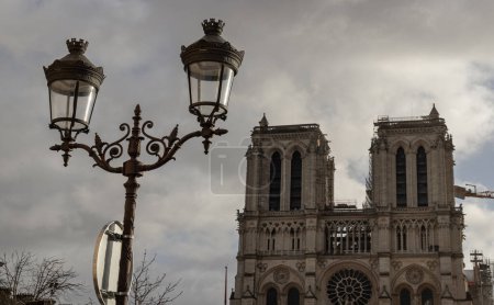 Photo for France, Paris - Jan 02, 2024 - Famous Notre Dame cathedral with Parisian streetlamps in the foreground. UNESCO World Heritage Site, Space for text, selective focus. - Royalty Free Image