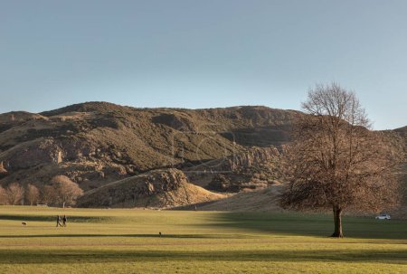 Téléchargez les photos : Le paysage pittoresque à couper le souffle du parc Holyrood avec les collines escarpées de Salisbury Crags et le fond du ciel. Vue de la ville d'Édimbourg. Espace pour le texte, Mise au point sélective. - en image libre de droit