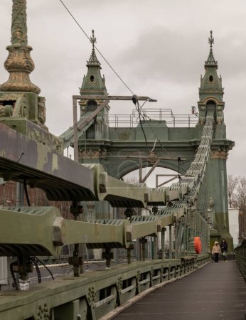 Photo for London, UK - Dec 25, 2023 - Traditional metal Hammersmith bridge for pedestrians and cyclists over the River thames. One of the world oldest suspension bridges and a major river crossing and primary route in west london, Cast-iron bridge, Space - Royalty Free Image