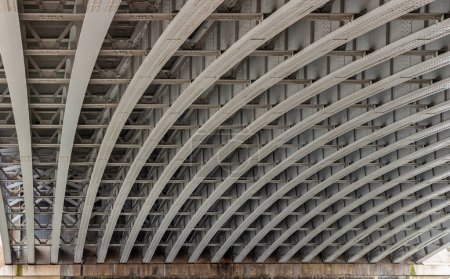 View of Structure and beams under the Curved steel Bridge. Framework metal arches girder construction Underneath of Blackfriars Bridge, Riveted steel beams supporting bridge span, Space for text, Selective focus.