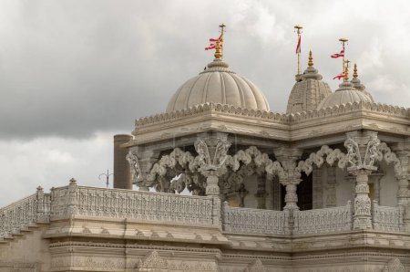 Photo for London, UK - Feb 23, 2024 - The exterior architectural design of the Neasden temple (BAPS Shri Swaminarayan Mandir) with sky background. Hindu temple in Neasden to build is constructed from Italian Marble, hand carved in India, space for text, Select - Royalty Free Image