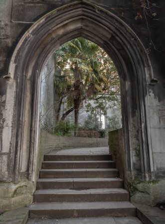 Photo for London, UK - Feb 27, 2024 - The stone arched entrance leads to the stone staircase inside of St Dunstan in the East Church Garden. The historic church was bombed and destroyed in the Second World War and is now a park, London city hidden places, Spac - Royalty Free Image