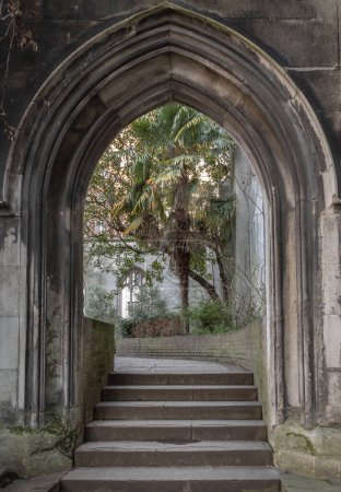 Photo for London, UK - Feb 27, 2024 - The stone arched entrance leads to the stone staircase inside of St Dunstan in the East Church Garden. The historic church was bombed and destroyed in the Second World War and is now a park, London city hidden places, Copy - Royalty Free Image