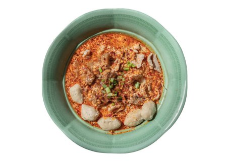 Würzige Tomyum-Reisspießnudeln (Thai-würzige Suppe) mit geschmortem Schweinefleisch (Kompott), frischem Schweinefleisch und Schweinebällchen bestreut mit Koriander, gehackten Zwiebeln und Pfeffer in grüner Keramikschüssel isoliert auf weißem Hintergrund mit Schneideweg. Draufsicht, Raum f