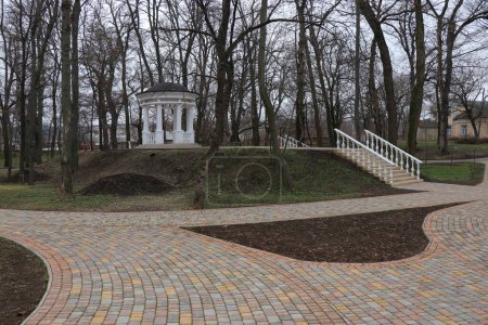 A beautiful park in spring. The paths of the ancient park leading to the new gazebos. Young trees begin to bloom in the park area