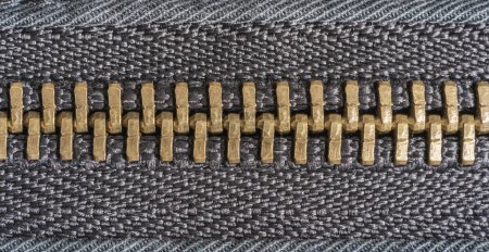 Foto de Macro primer plano de una cremallera de oro fuertemente cerrado juntos en una chaqueta negra - Imagen libre de derechos