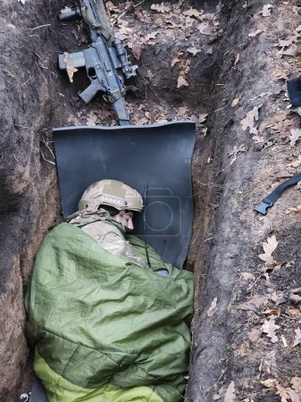 Foto de Bakhmut, Ucrania - 28 de noviembre de 2022: las posiciones de las Fuerzas Armadas de Ucrania cerca de Bakhmut. Un sargento del pelotón de reconocimiento del 23º batallón especial por separado duerme en un - Imagen libre de derechos