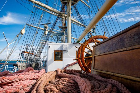 Téléchargez les photos : Sailship deck with helm, rigging and cables - en image libre de droit