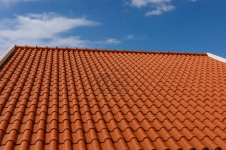 Photo for Red tiles panels roof under blue sky - Royalty Free Image