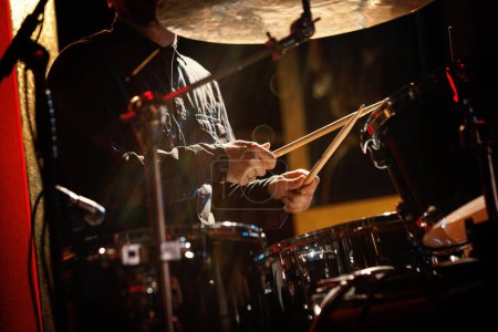 Close-up of drummer drumsticks with a drum set