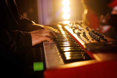 A musician plays modern piano keyboards during a concert performance