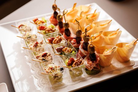 An elegant display of various appetizers on a white platter.