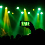 Making photo with smartphone during a concert to share the moment with friends on social networks