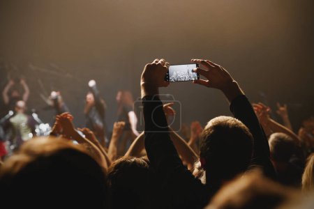 Un momento fascinante se desarrolla en un concierto en vivo, grabado a través de la cámara del teléfono móvil