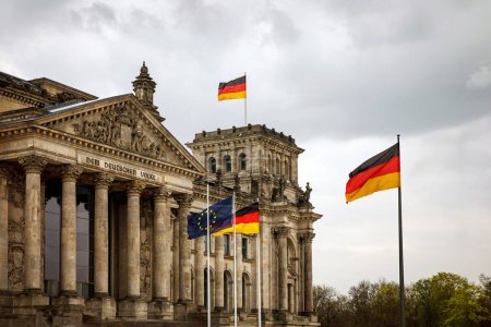 Die deutsche Fahne weht am Bundestag, dem Gebäude des Deutschen Bundestages. Bewölkter Himmel