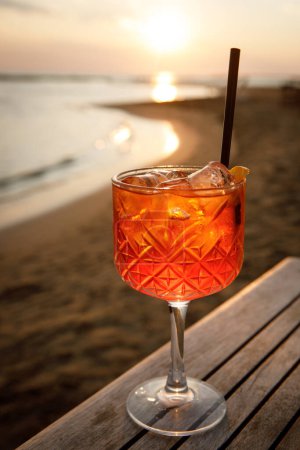 Aperol spritz cocktail in a tulip glass on a summer evening during sunset