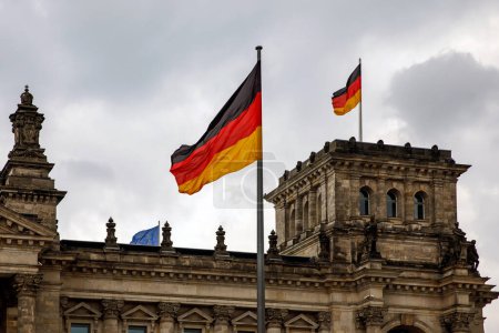 Die deutsche Fahne weht am Bundestag, dem Gebäude des Deutschen Bundestages. Bewölkter Himmel