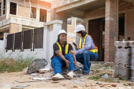 Photo for Successful and construction work Concept.female architect, inspecting work with african american engineer talking, consulting together and serious workfinished  to plan on housing construction project site. - Royalty Free Image
