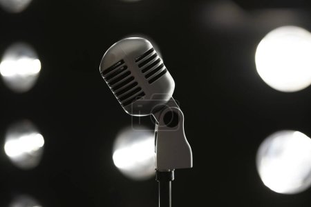  Mikrofon auf einem Stativ in Nahaufnahme vor dem Hintergrund von Scheinwerfern                              