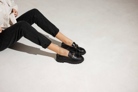 Téléchargez les photos : Mocassins noirs sur les jambes féminines close-up - en image libre de droit