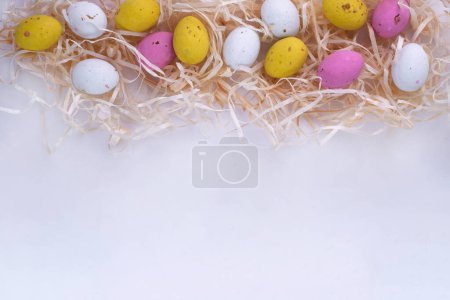 Foto de Colección de huevos de Pascua en honor de la Pascua en la maqueta de heno para la tarjeta de felicitación - Imagen libre de derechos