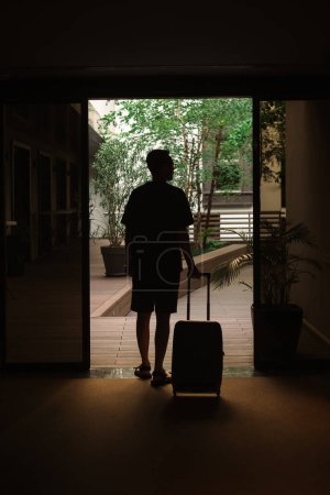 Foto de Un turista con una maleta sale del hotel - Imagen libre de derechos