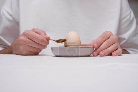 Foto de Hombre pelando un huevo en un primer plano de las manos - Imagen libre de derechos