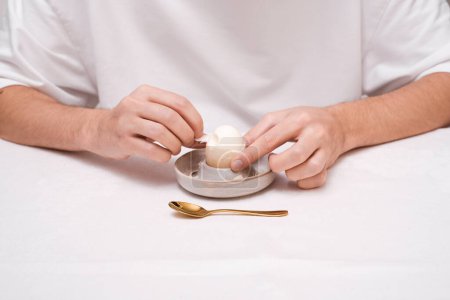 Foto de Un hombre come un huevo para desayunar en un tazón escalfado vista superior - Imagen libre de derechos