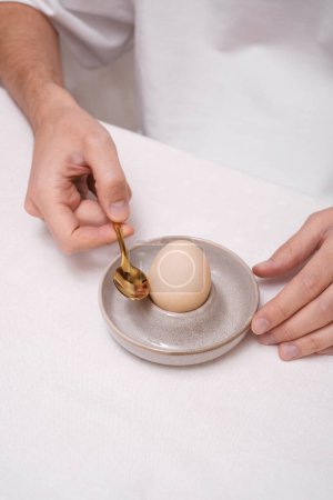 Foto de Hombre pelando un huevo en un primer plano de las manos - Imagen libre de derechos