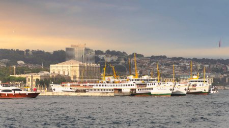 Foto de View of the European coast of the Bosporus strait in Besiktas district with docked ferry boats, and Dolmabahce Palace in the background, Istanbul, Turkey - Imagen libre de derechos