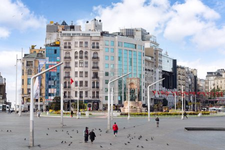 Foto de Estambul, Turquía - 13 de mayo de 2023: Escena callejera en la Plaza Taksim, con edificios altos, incluyendo el Hotel Taksim Hill y el Hotel SOFITEL y peatones ambulantes - Imagen libre de derechos