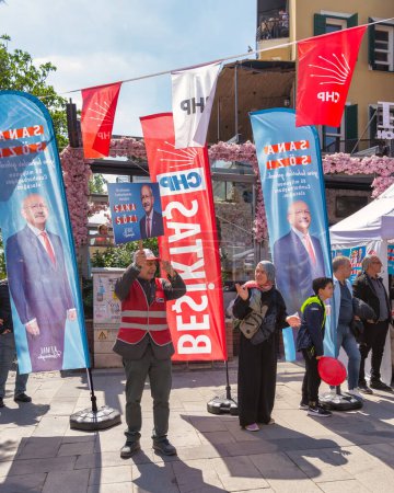 Photo for Istanbul, Turkey - May 13 2023: Man waving a big poster with Kemal Kilicdaroglu photo in front of Republican Peoples Party kiosk in the neighbourhood of Ortakoy during the 2023 elections - Royalty Free Image