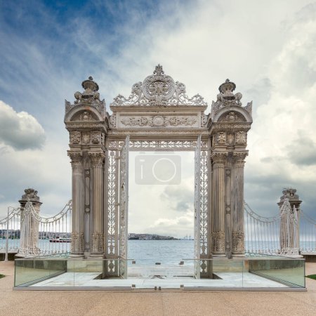 Pair of elaborately decorated white painted metal gates leading to the opulent Dolmabahce Palace in Istanbul, Turkey, and offering stunning views of the Bosphorus Strait