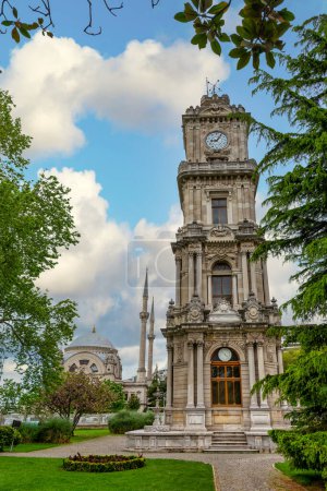 Foto de la mañana de la Torre del Reloj Dolmabahce, o Dolmabahce Saat Kulesi, situado fuera del Palacio Dolmabahce, Estambul, Turquía, con el estilo barroco de la Mezquita Dolmabahce en el fondo