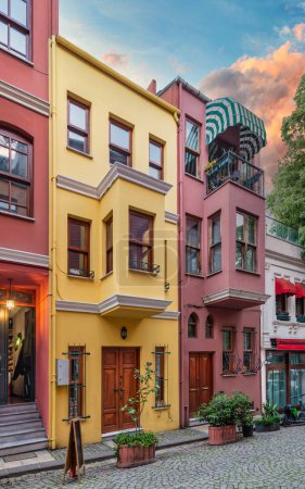 Façade de bâtiments résidentiels colorés peints en rouge et jaune, dans une ruelle pavée adaptée au quartier Kuzguncuk, district d'Uskudar, Istanbul, Turquie