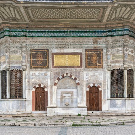 Marble fountain of Sultan Ahmed III, or Ahmet Cesmesi, a 17th century Turkish rococo water fountain, or Sebil, located in the Great Square, beside the Imperial Gate of Topkapi Palace, Istanbul, Turkey